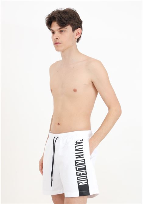 Shorts mare bianco da uomo con maxi stampa logo CALVIN KLEIN | Beachwear | KM0KM00991YCD