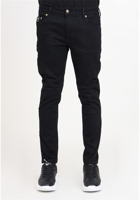 Black skinny fit men's trousers with golden metal logo label VERSACE JEANS COUTURE | 76GAB540CDW00909